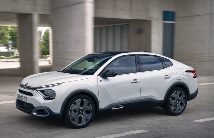 White Citroen e-C4X side profile view while driving